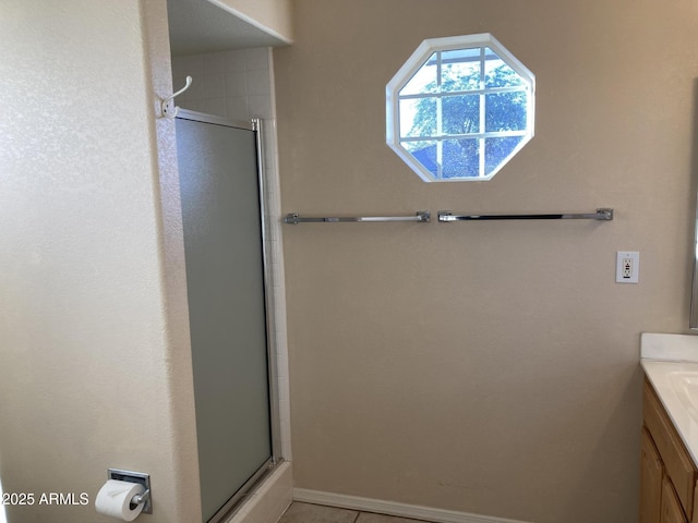 bathroom with tile patterned flooring, vanity, and walk in shower