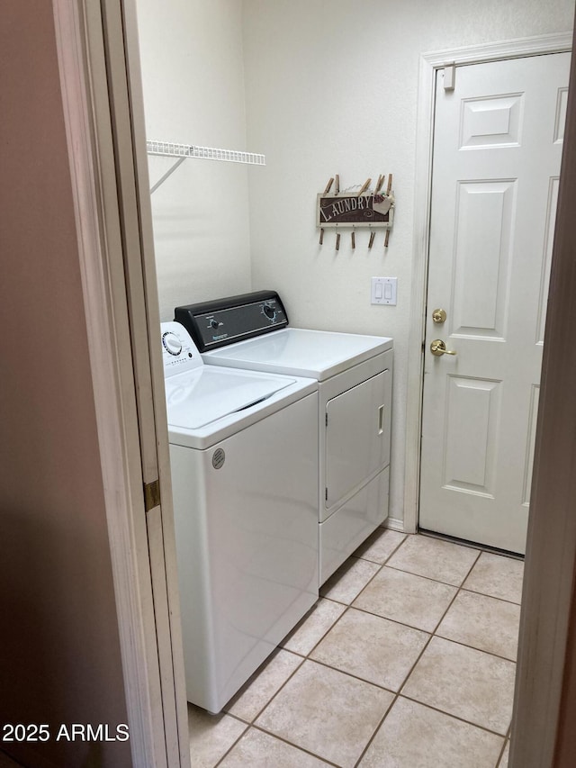 washroom featuring washer and dryer and light tile patterned flooring