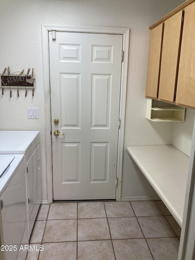 washroom with washing machine and clothes dryer, light tile patterned floors, and cabinets