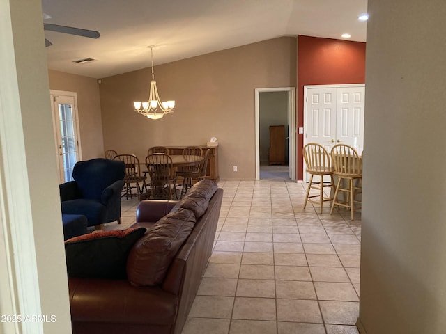 tiled living room featuring ceiling fan with notable chandelier and lofted ceiling