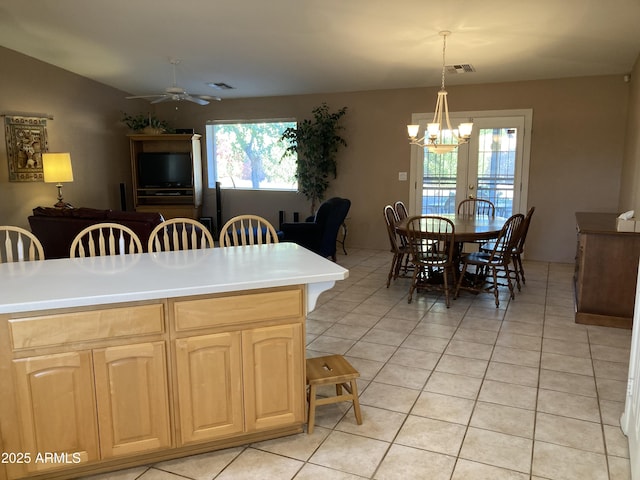 kitchen featuring french doors, ceiling fan with notable chandelier, light tile patterned floors, light brown cabinets, and decorative light fixtures