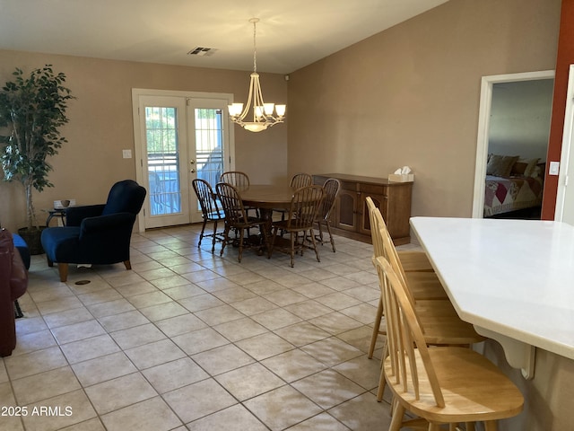 dining area with light tile patterned floors, an inviting chandelier, and french doors