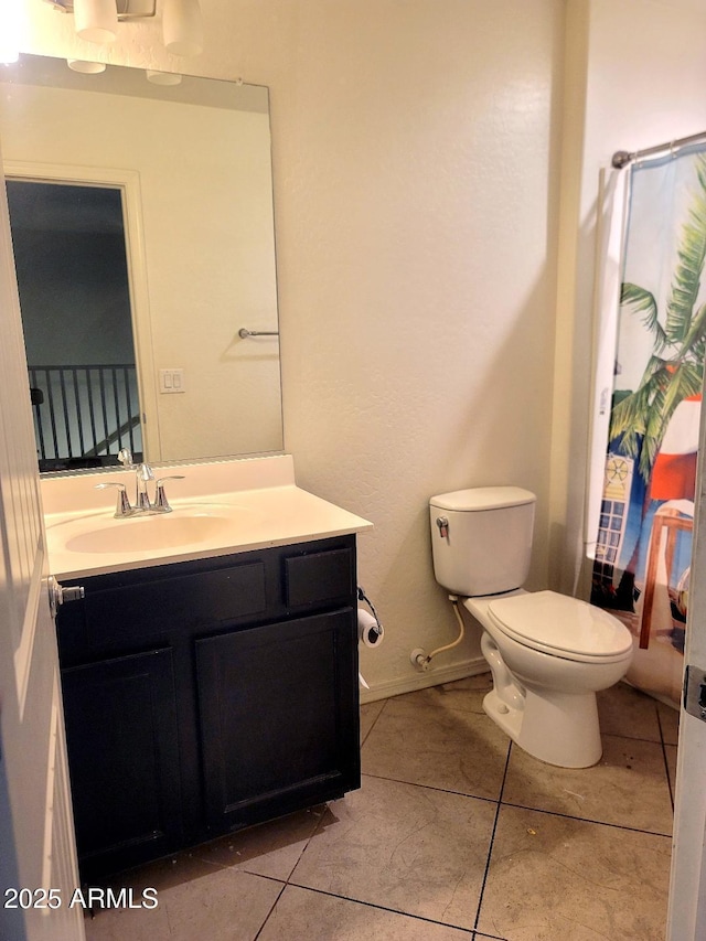 bathroom with toilet, tile patterned flooring, and vanity