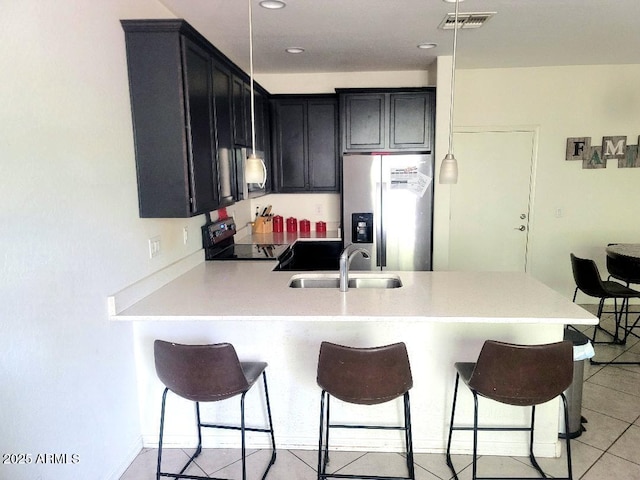 kitchen with sink, stainless steel fridge, black electric range oven, kitchen peninsula, and a breakfast bar