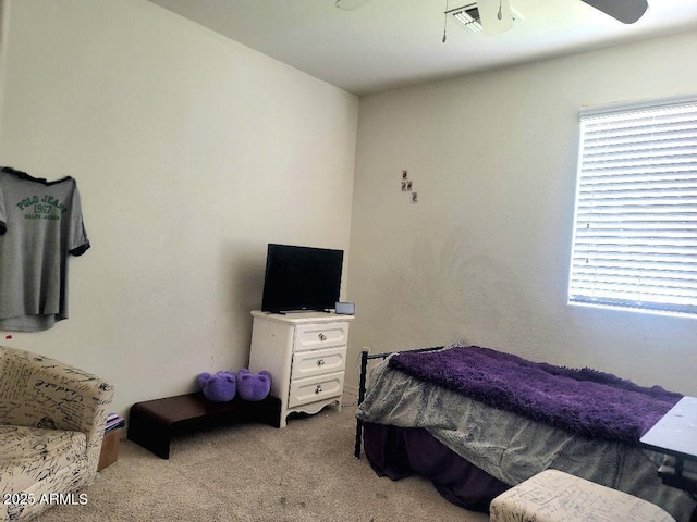 bedroom featuring ceiling fan, light colored carpet, and multiple windows