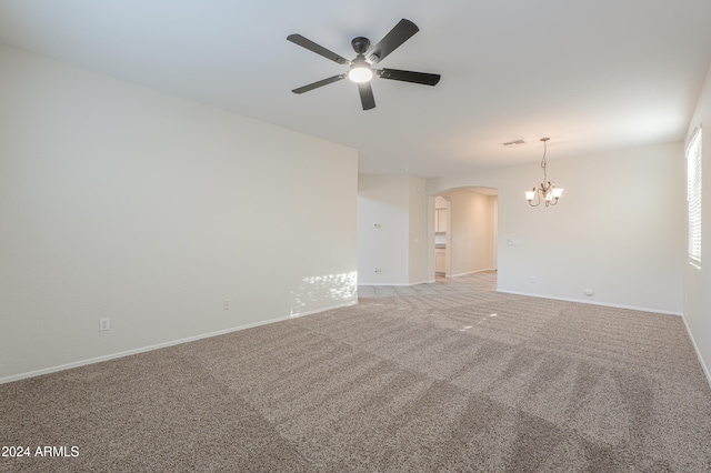 carpeted empty room with ceiling fan with notable chandelier