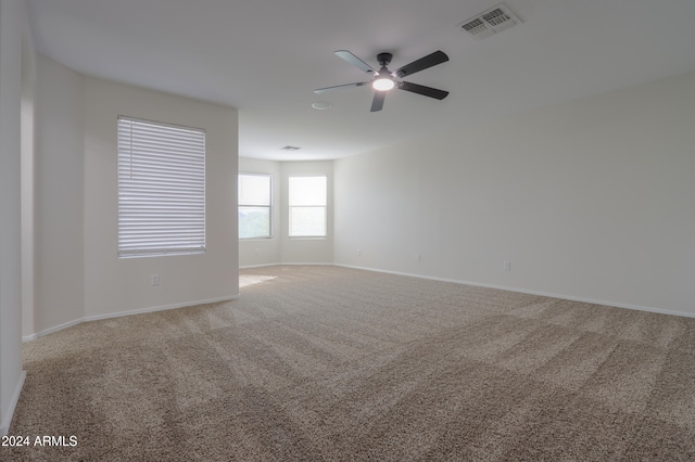 carpeted spare room featuring ceiling fan