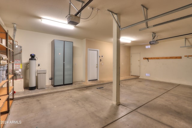 garage featuring strapped water heater and a garage door opener