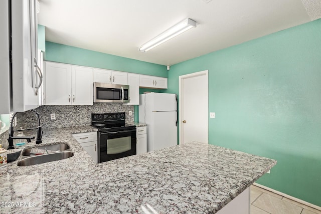 4624 S Fair Ln, Tempe, AZ 85282 - kitchen with stainless steel microwave, black range with electric stovetop, freestanding refrigerator, a sink, and light stone countertops