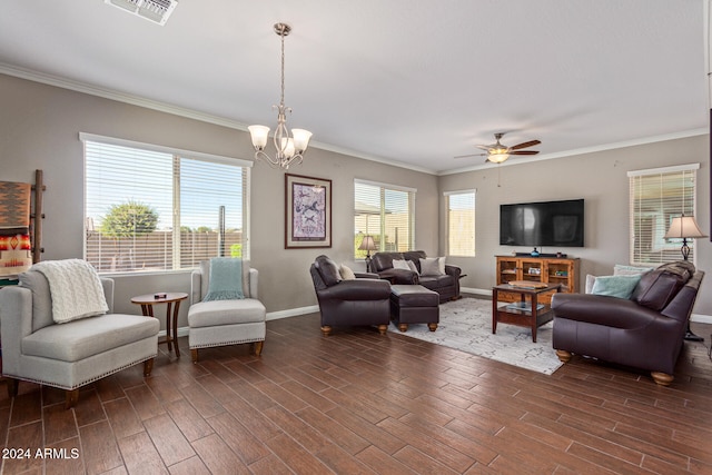 living room featuring dark wood-type flooring, ceiling fan with notable chandelier, a healthy amount of sunlight, and crown molding