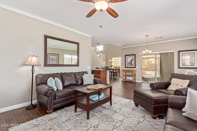 living room with ceiling fan with notable chandelier, hardwood / wood-style flooring, and crown molding