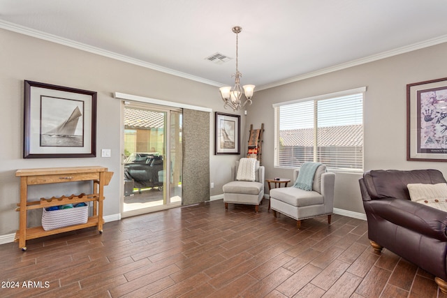 sitting room with dark hardwood / wood-style floors, crown molding, and a notable chandelier