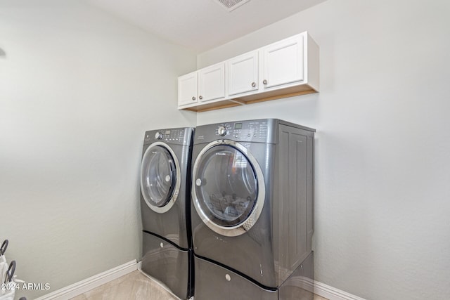 clothes washing area featuring cabinets and independent washer and dryer