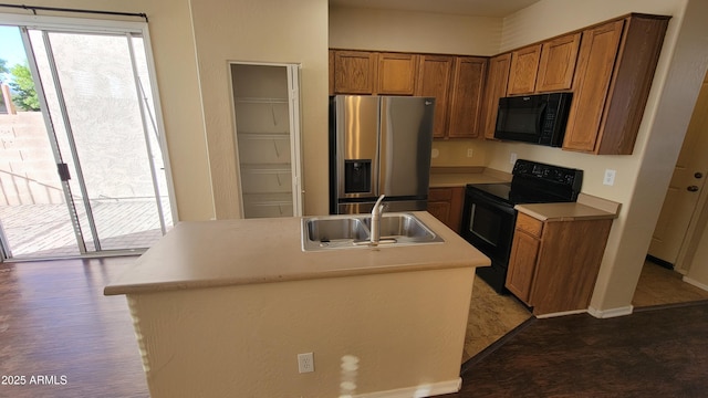 kitchen with brown cabinets, a healthy amount of sunlight, a sink, and black appliances