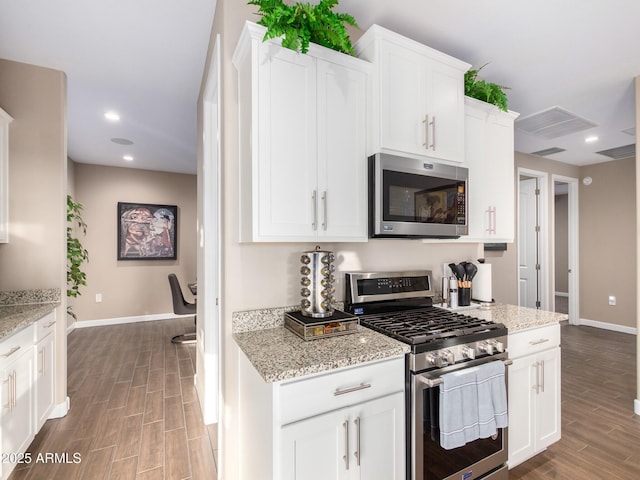 kitchen featuring light stone countertops, white cabinets, and stainless steel appliances