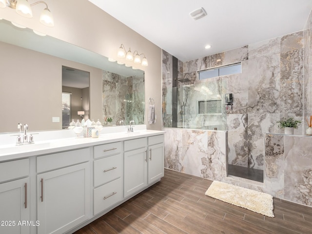 bathroom with vanity and a tile shower