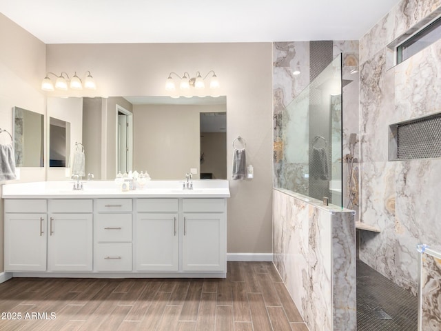 bathroom with tiled shower and vanity