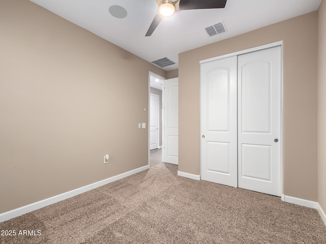 unfurnished bedroom featuring ceiling fan, a closet, and light carpet