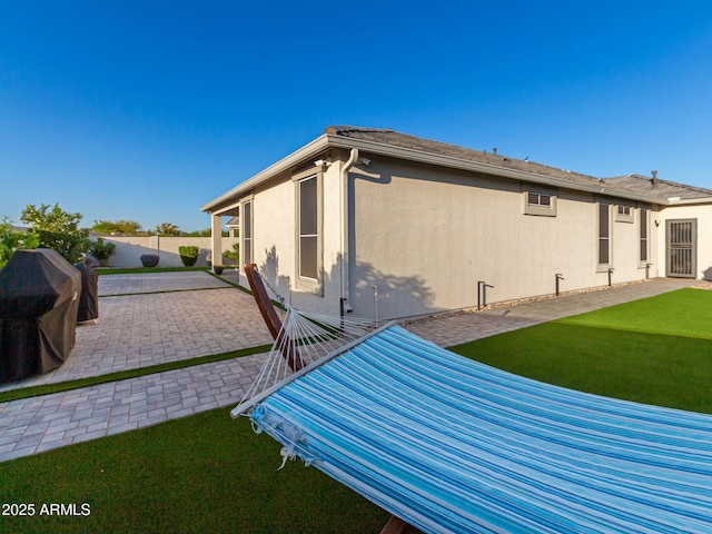 view of side of property with a yard and a patio