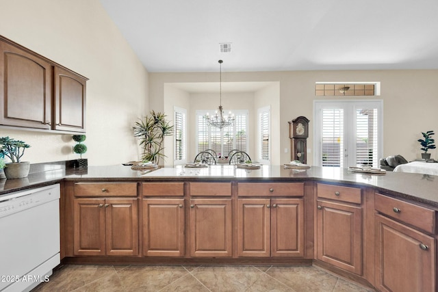 kitchen featuring white dishwasher, decorative light fixtures, kitchen peninsula, and an inviting chandelier