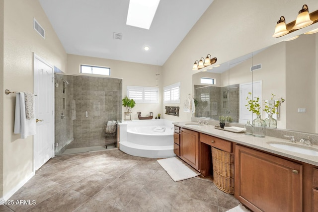 bathroom with tile patterned floors, vanity, separate shower and tub, and vaulted ceiling with skylight