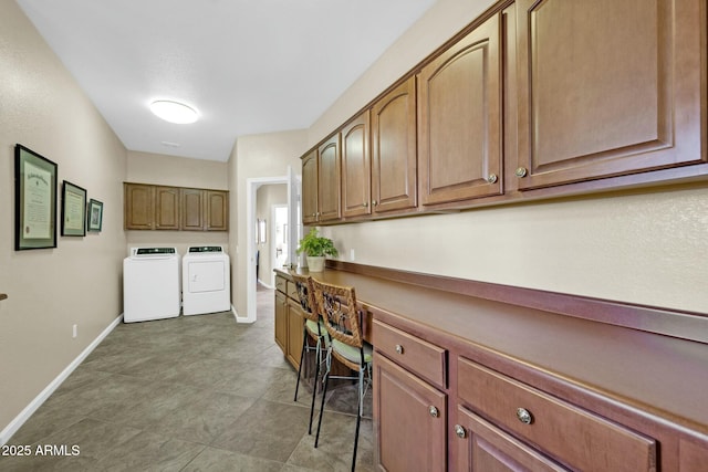 laundry room featuring washing machine and clothes dryer and cabinets