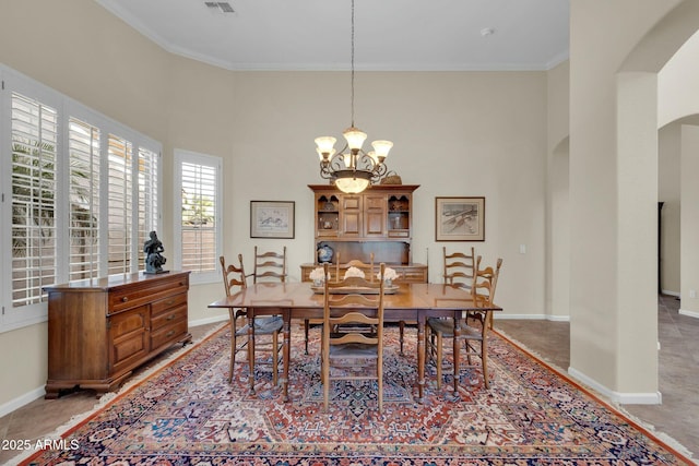 dining room with ornamental molding and a notable chandelier