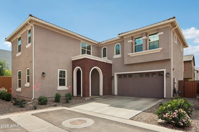 mediterranean / spanish-style home featuring stucco siding, concrete driveway, an attached garage, fence, and a tile roof