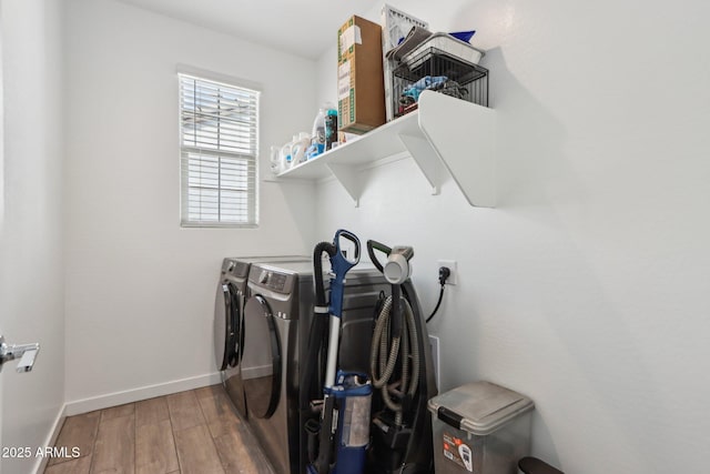 washroom with washing machine and clothes dryer, wood finished floors, and baseboards