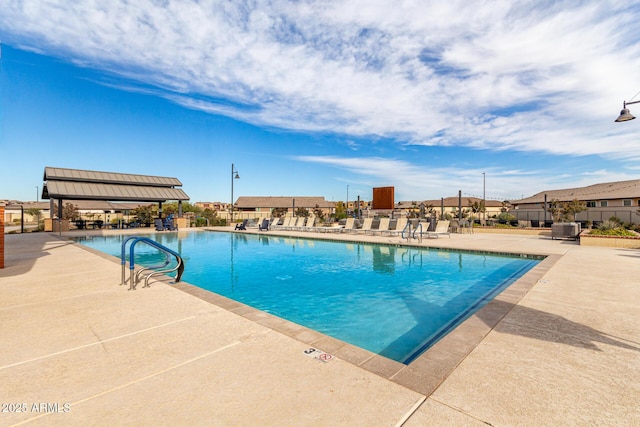 community pool with a patio area and fence