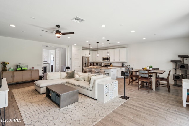 living area featuring light wood finished floors, recessed lighting, and ceiling fan