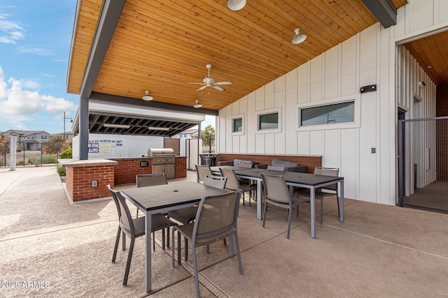 view of patio with outdoor dining space, an outdoor kitchen, a ceiling fan, and grilling area