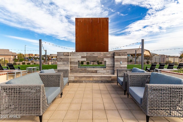 view of patio with an outdoor stone fireplace and fence