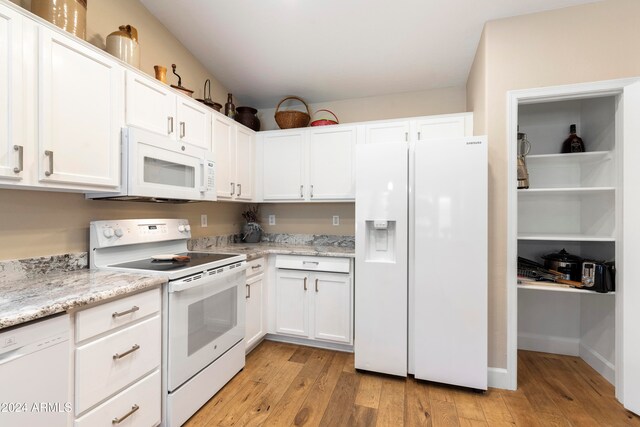 kitchen with white cabinets, white appliances, light hardwood / wood-style flooring, and light stone countertops