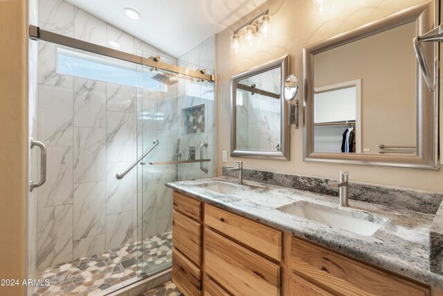 bathroom featuring a shower with door, vanity, and lofted ceiling