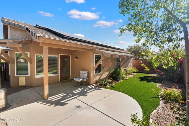 rear view of property with a yard and a patio area