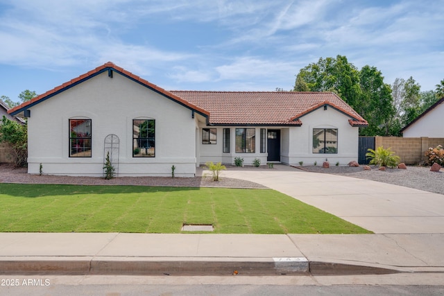 mediterranean / spanish home with a tile roof, stucco siding, and driveway