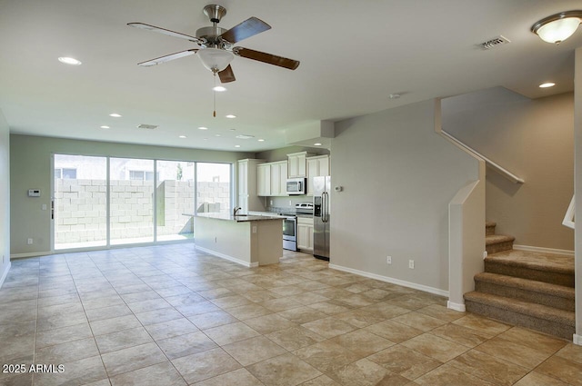 4242 E Erie St, Gilbert, AZ 85295 - kitchen with stainless steel appliances, open floor plan, ceiling fan, white cabinets, and recessed lighting
