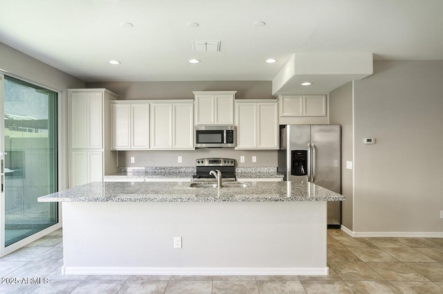 4242 E Erie St, Gilbert, AZ 85295 - kitchen with stainless steel appliances, a sink, an island with sink, white cabinetry, and light stone countertops