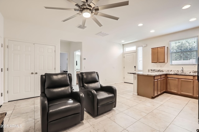 7665 W Fetlock Trl, Peoria, AZ 85383 - kitchen featuring brown cabinets, light tile patterned floors, a ceiling fan, recessed lighting, and a peninsula