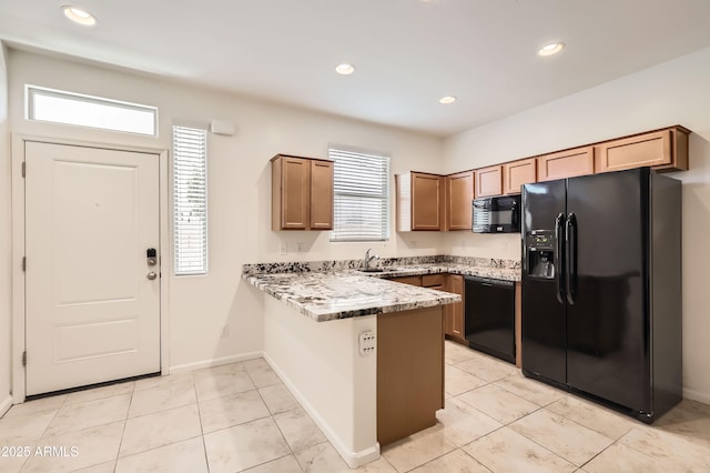 7665 W Fetlock Trl, Peoria, AZ 85383 - kitchen featuring black appliances, a peninsula, healthy amount of natural light, brown cabinetry, and recessed lighting
