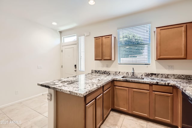 7665 W Fetlock Trl, Peoria, AZ 85383 - kitchen with a peninsula, light tile patterned floors, light stone counters, brown cabinetry, and recessed lighting