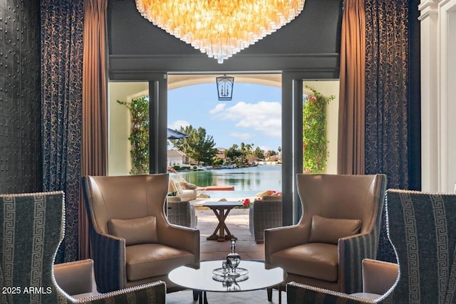 living area featuring a water view and a notable chandelier