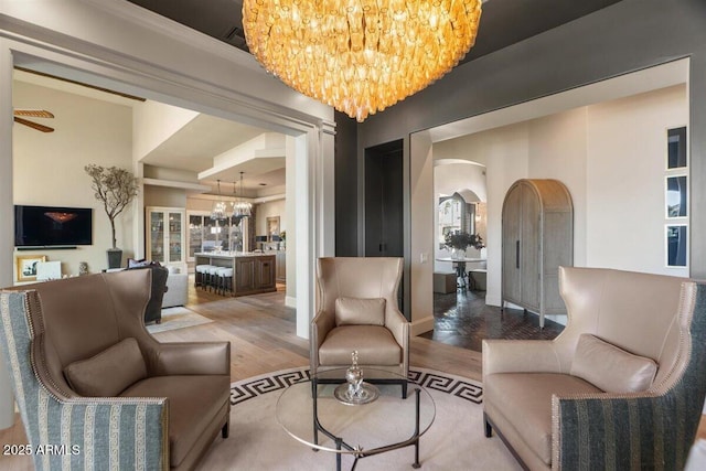 living room featuring wood-type flooring and ceiling fan with notable chandelier