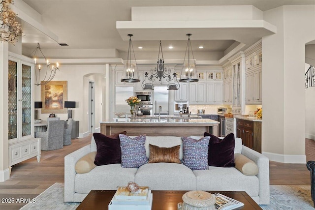 living room with hardwood / wood-style floors, sink, and a chandelier