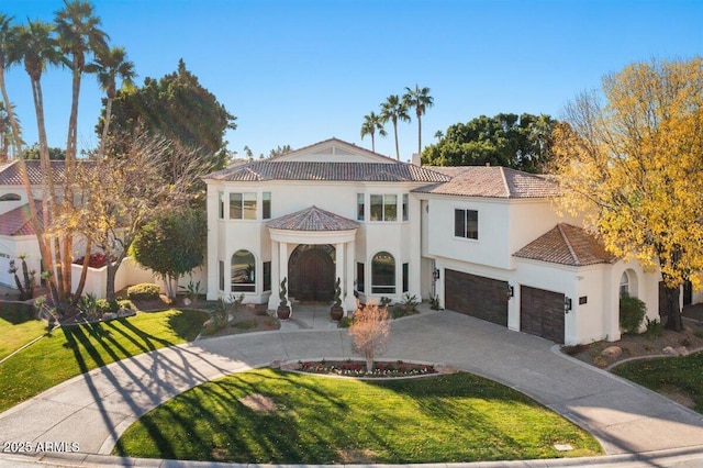 mediterranean / spanish-style house featuring a garage and a front yard