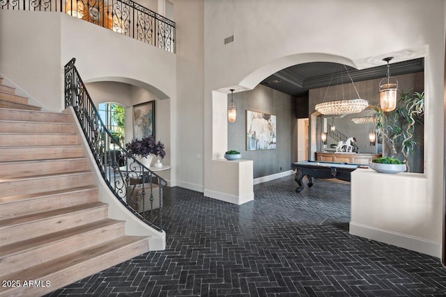 entrance foyer with crown molding, a towering ceiling, and billiards