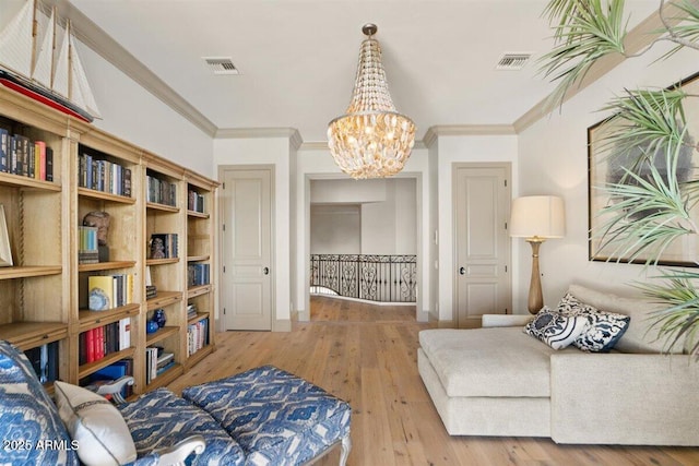 living area with crown molding, hardwood / wood-style floors, and a notable chandelier