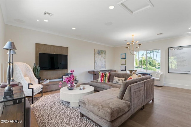 living room with hardwood / wood-style flooring, crown molding, and a notable chandelier