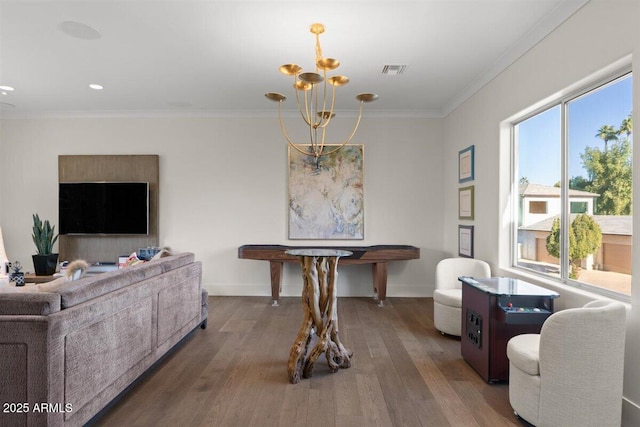 dining area featuring ornamental molding, wood-type flooring, and a notable chandelier